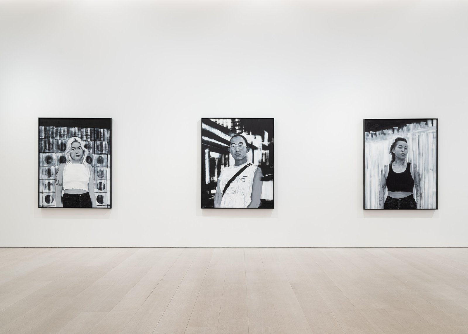 A bright art gallery with black and white paintings on the walls